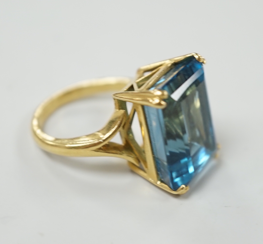 An 18ct and emerald cut blue topaz set dress ring, size K, gross weight 11 grams.